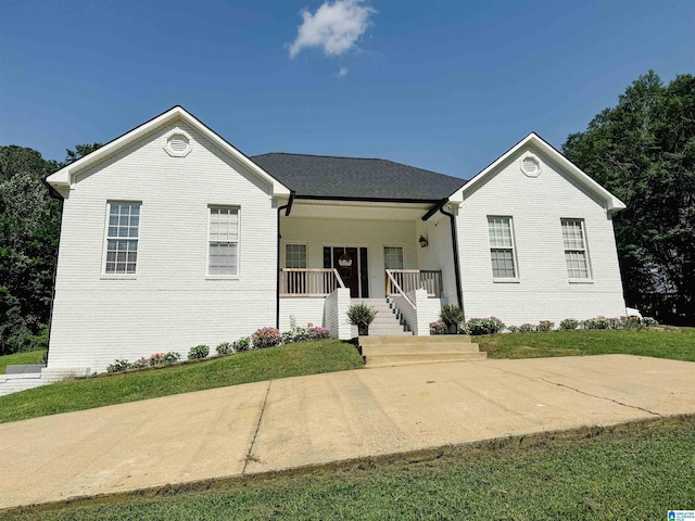 ranch-style house with a porch, a front lawn, and brick siding