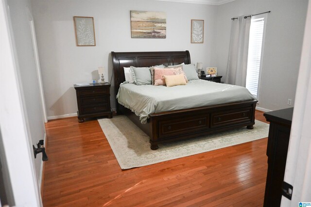 bedroom with wood-type flooring and ornamental molding