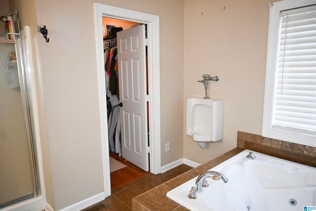 bathroom with shower with separate bathtub and tile patterned floors