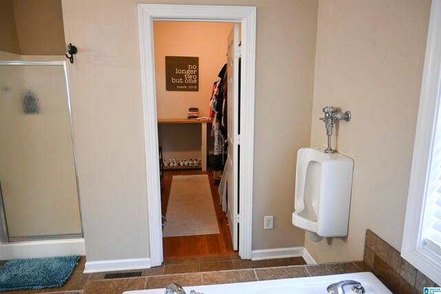 bathroom with independent shower and bath and hardwood / wood-style flooring