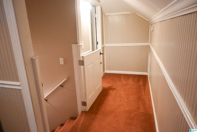 hall with carpet floors and vaulted ceiling