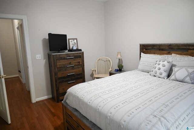 bedroom featuring dark wood-style flooring and baseboards