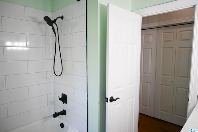 bathroom featuring tiled shower / bath combo and hardwood / wood-style flooring