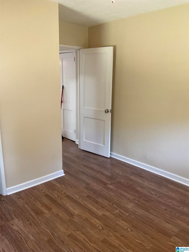 unfurnished room with dark hardwood / wood-style floors