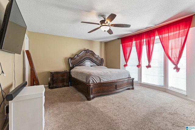 bedroom featuring carpet, a textured ceiling, and ceiling fan