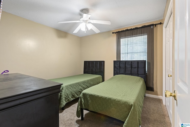 carpeted bedroom featuring ceiling fan and a textured ceiling