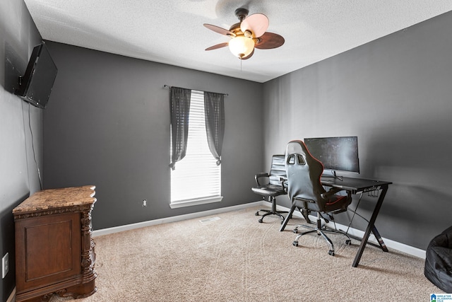 carpeted office space with ceiling fan and a textured ceiling