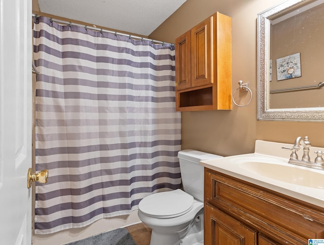 bathroom with walk in shower, vanity, toilet, and a textured ceiling