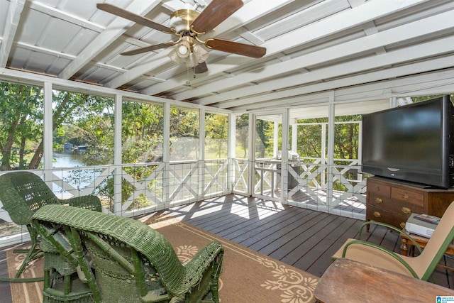 sunroom featuring a wealth of natural light, ceiling fan, and a water view