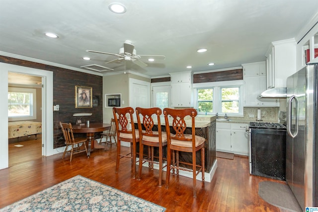 dining area featuring ornamental molding, sink, ceiling fan, and dark hardwood / wood-style flooring