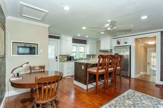 kitchen featuring crown molding, a center island, stainless steel fridge with ice dispenser, dark hardwood / wood-style flooring, and white cabinets