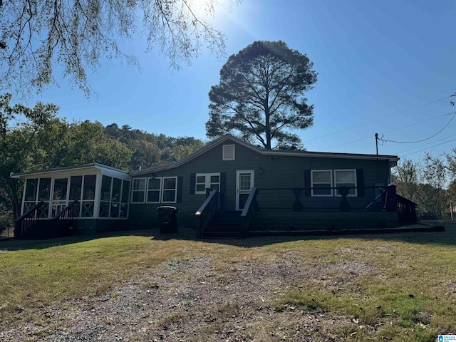 back of house featuring a sunroom and a yard