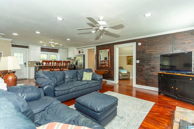 living room with crown molding, ceiling fan, and dark hardwood / wood-style flooring