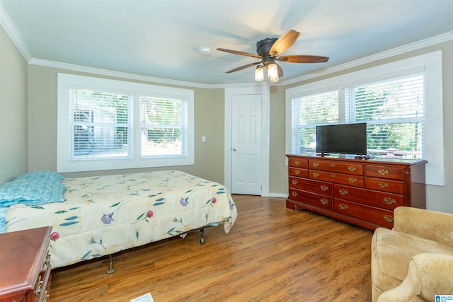 bedroom featuring crown molding, ceiling fan, a closet, and light hardwood / wood-style flooring