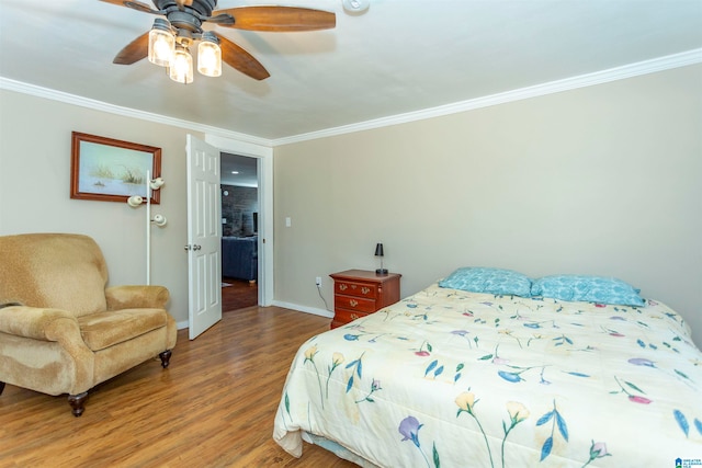 bedroom featuring hardwood / wood-style flooring, ornamental molding, and ceiling fan