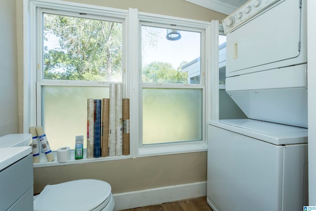 interior space featuring stacked washer / drying machine, hardwood / wood-style flooring, and a wealth of natural light