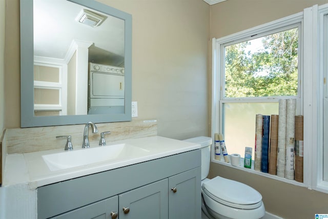 bathroom featuring vanity, toilet, and washer / dryer