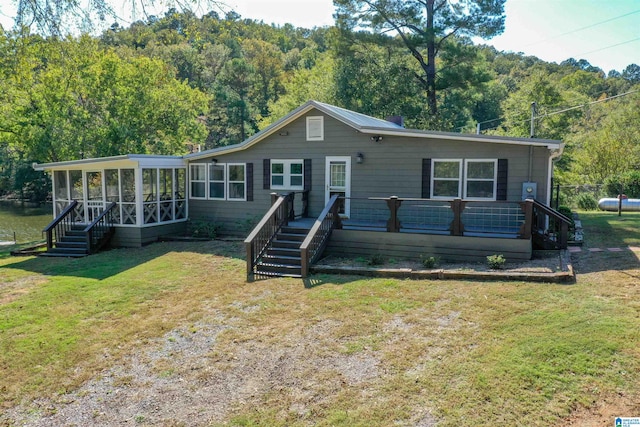 view of front of home featuring a sunroom and a front lawn