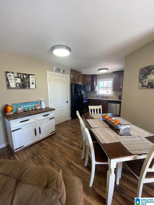 dining space with dark hardwood / wood-style flooring, a textured ceiling, and sink