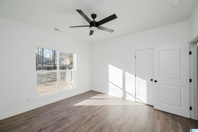 empty room with ceiling fan and hardwood / wood-style flooring