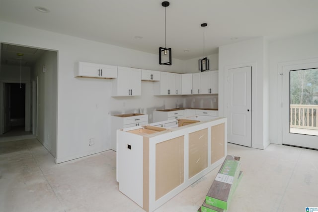 kitchen with a center island, white cabinetry, and hanging light fixtures