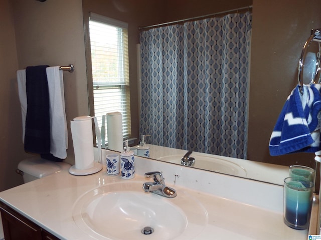 bathroom with vanity, curtained shower, and toilet