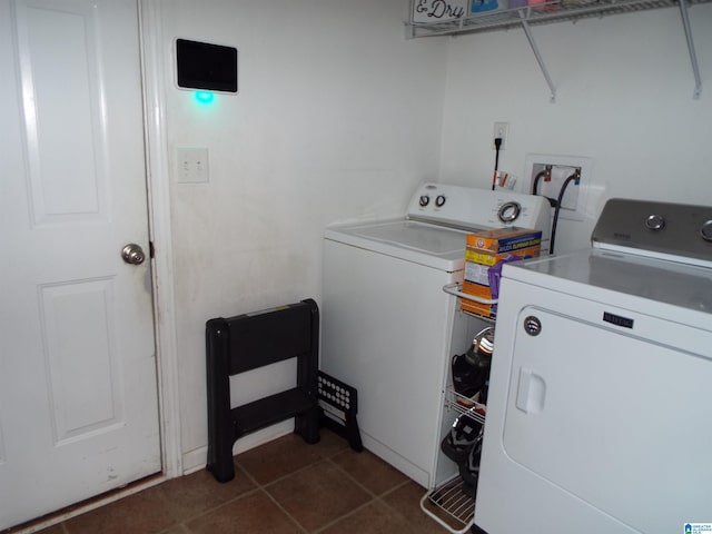 laundry area featuring washer and dryer and dark tile patterned floors