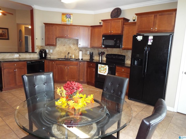 kitchen featuring sink, black appliances, crown molding, and light tile patterned floors