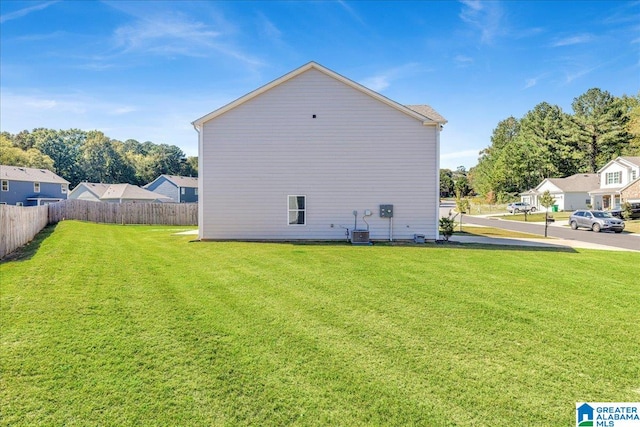 back of house featuring a yard and central AC