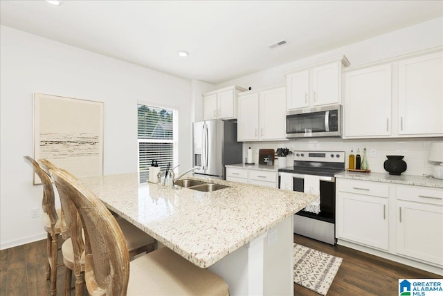 kitchen featuring white cabinets, a kitchen island with sink, and appliances with stainless steel finishes