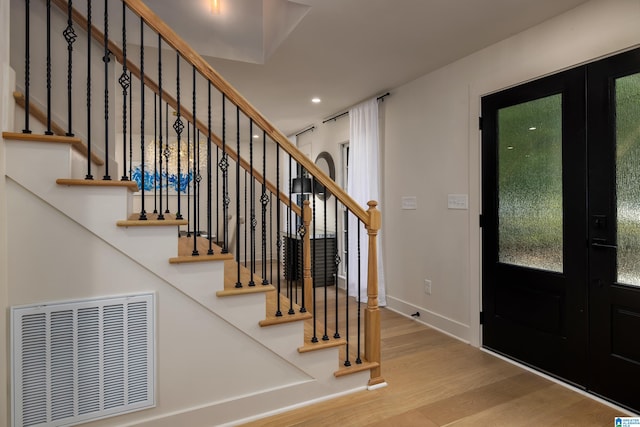 entryway with french doors and light hardwood / wood-style floors