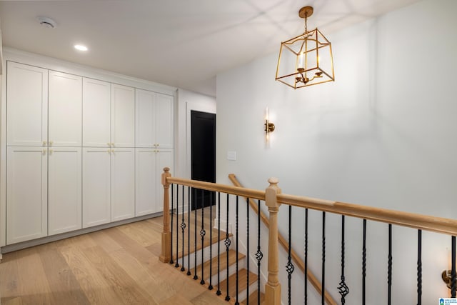 hall featuring a chandelier and light hardwood / wood-style floors