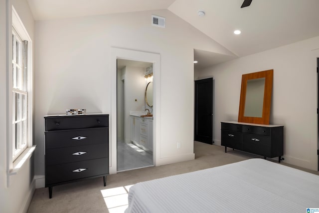 carpeted bedroom featuring ceiling fan, vaulted ceiling, and ensuite bath