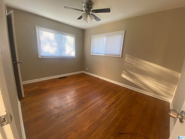 spare room with dark wood-type flooring and ceiling fan