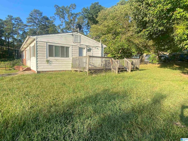 rear view of property with a yard and a wooden deck