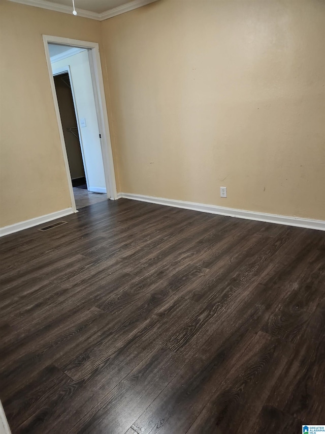 empty room featuring dark hardwood / wood-style floors and crown molding