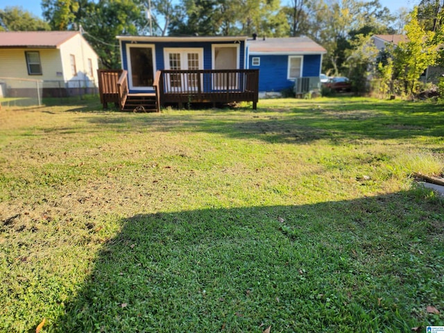 rear view of property with a lawn and a wooden deck