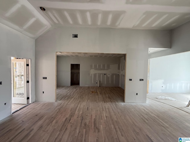 unfurnished living room featuring high vaulted ceiling and wood finished floors