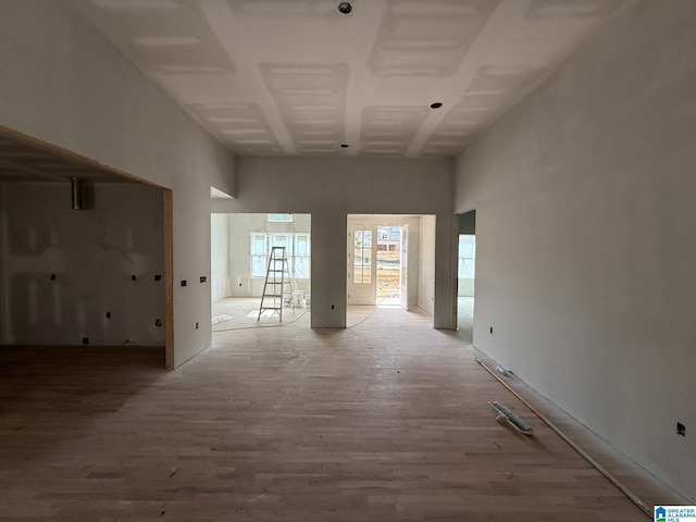 interior space featuring a towering ceiling and light wood-style floors