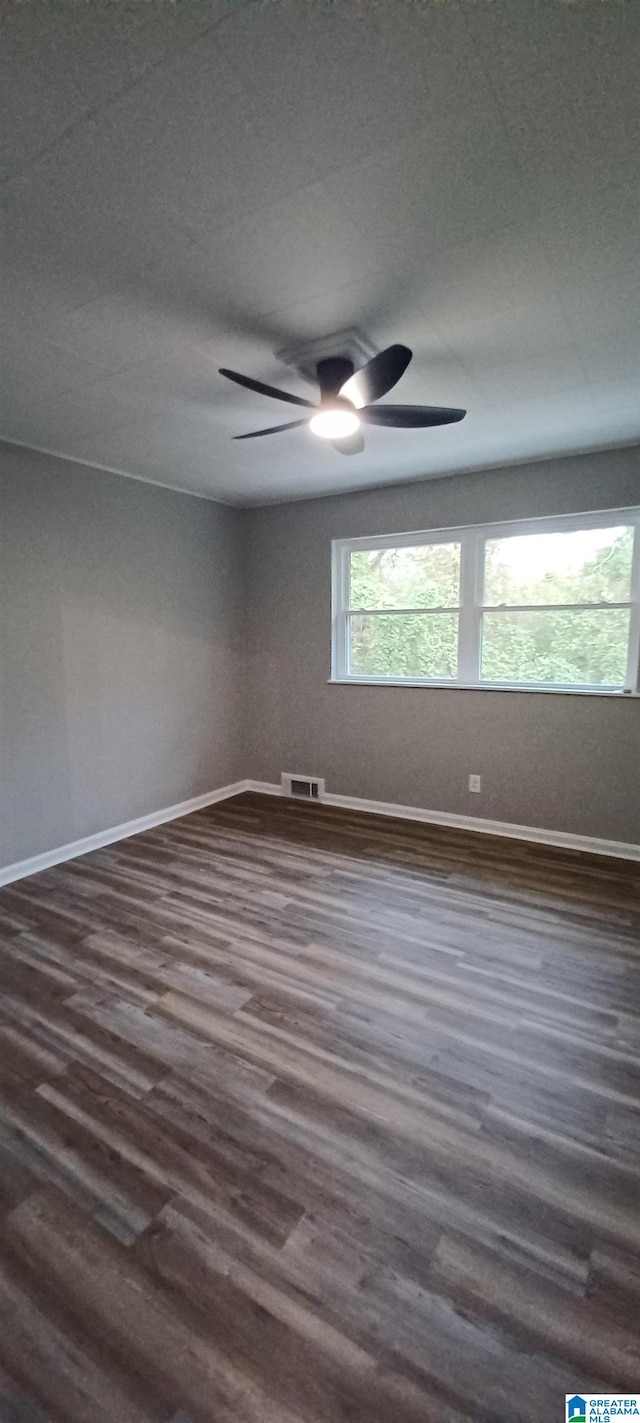 empty room with dark hardwood / wood-style floors and ceiling fan