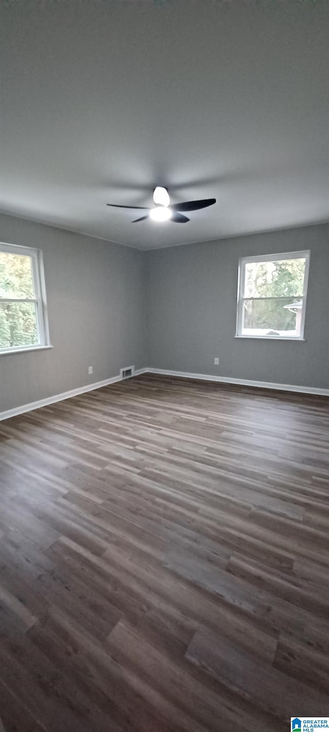 spare room with dark wood-type flooring and ceiling fan