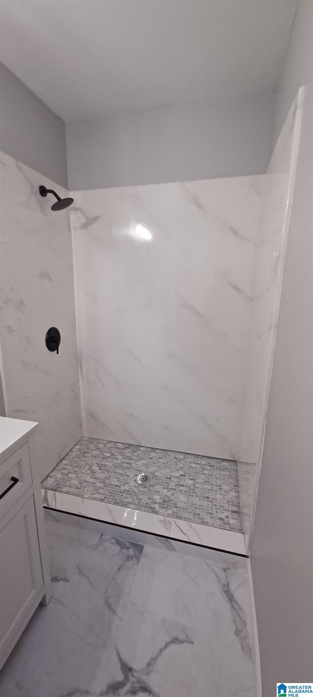 bathroom featuring a tile shower and vanity