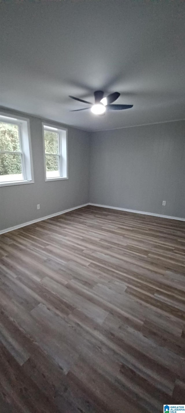 unfurnished room featuring dark wood-type flooring and ceiling fan