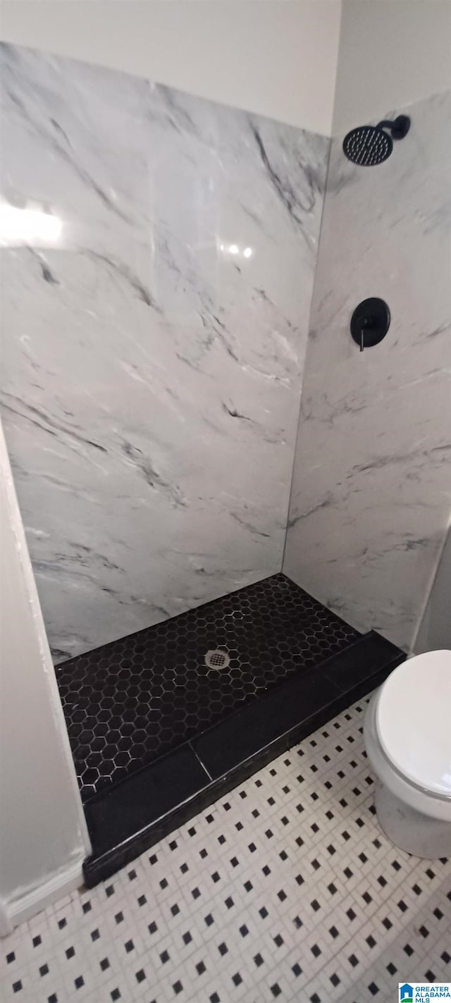 bathroom with toilet and a tile shower