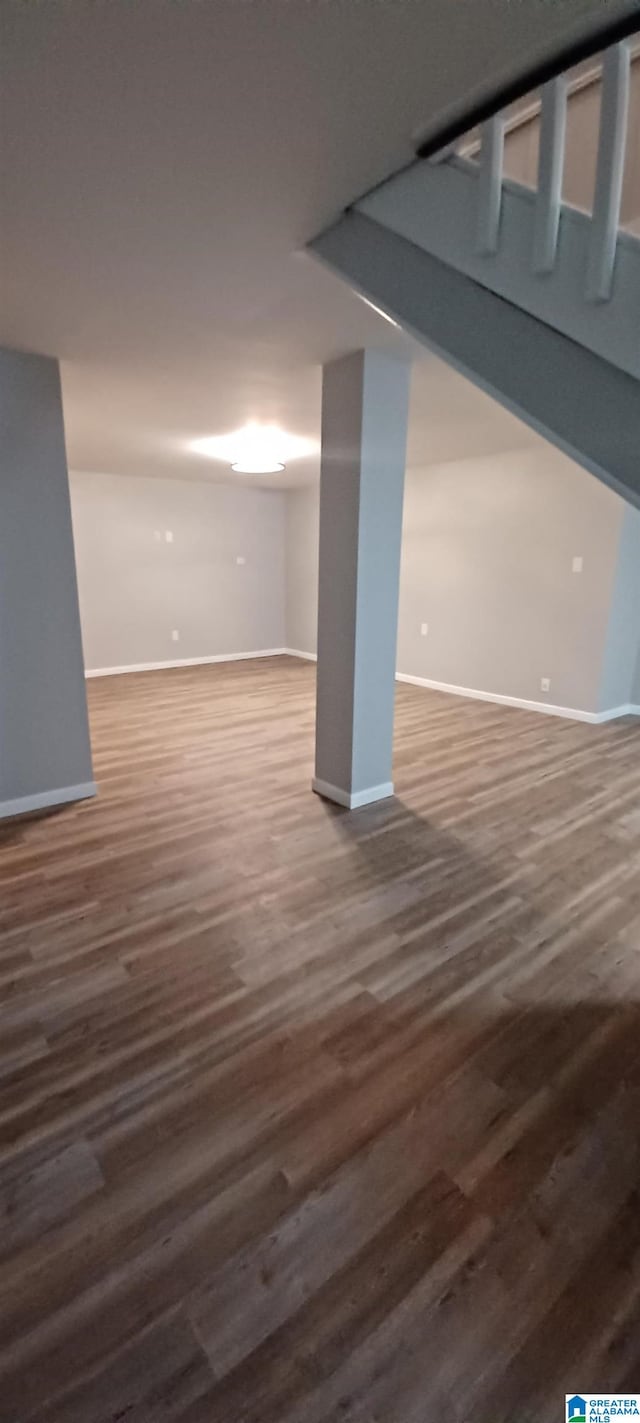 basement with dark hardwood / wood-style floors