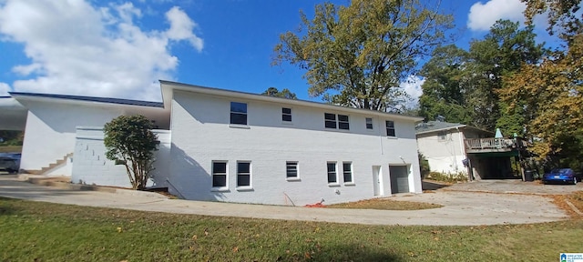 back of property with a garage and a yard