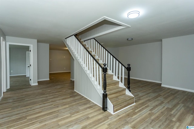 staircase with hardwood / wood-style floors