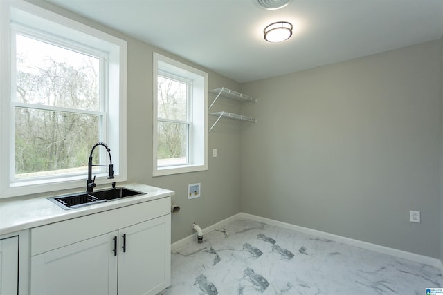 laundry room with hookup for a washing machine, sink, and cabinets