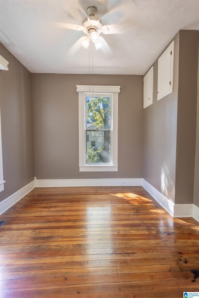 unfurnished dining area featuring light wood-type flooring, ceiling fan, and a textured ceiling