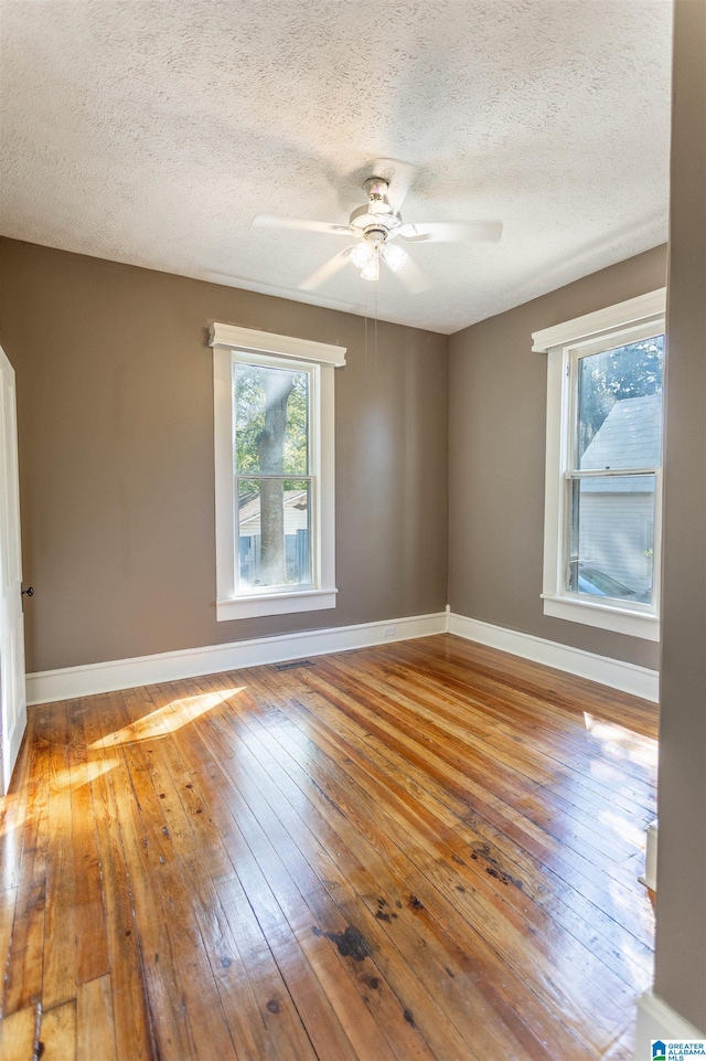 spare room featuring wood-type flooring, a textured ceiling, and ceiling fan